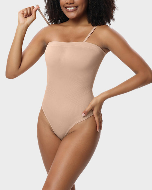 Woman wearing a beige bodysuit against a plain background